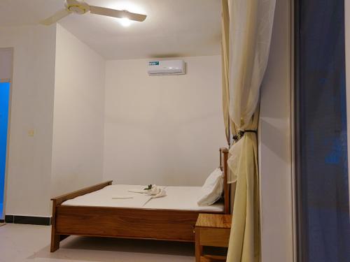 a small room with a bed with a white sheet at 2BR Beachfront Apartment with Balcony & Sea Views - Uroa, Zanzibar in Uroa