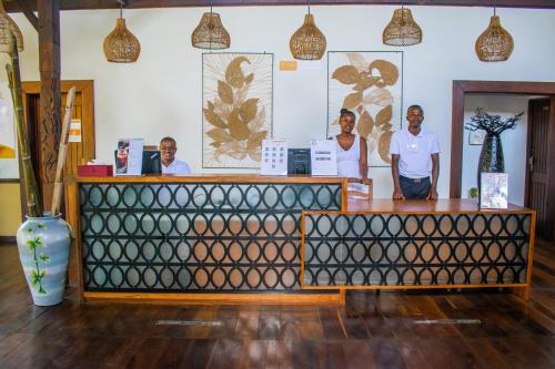 a group of three men standing behind a counter at Vanila Hotel & Spa in Ambaro