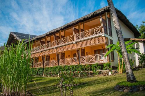 an exterior view of a resort with palm trees at Vanila Hotel & Spa in Ambaro