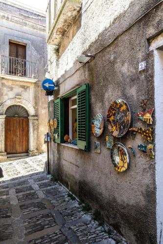 an alley with a window and plates on the side of a building at Porta Trapani rooms & suites in Erice