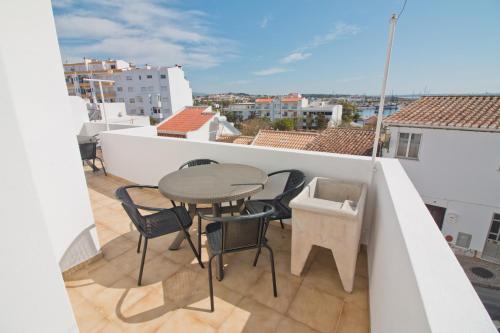 a balcony with a table and chairs on a roof at New Village Guest House in Lagos