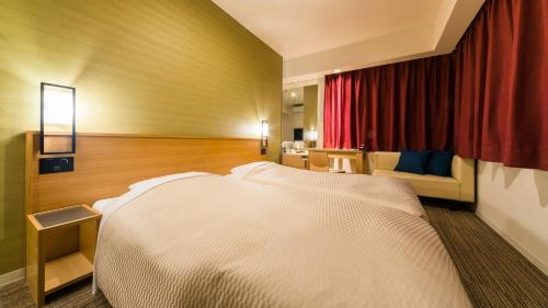 a bedroom with a white bed and a red curtain at Candeo Hotels Fukuoka Tenjin in Fukuoka