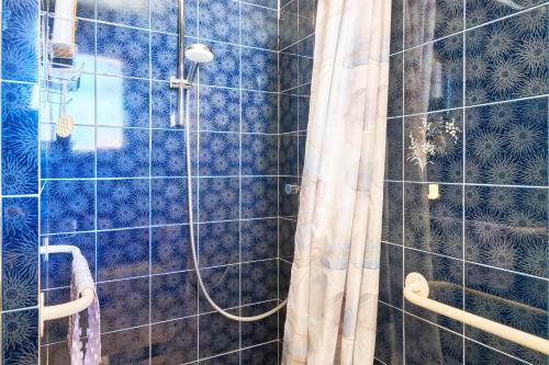 a shower with a shower curtain in a bathroom at Les chambres de Ma'nous - Dordogne in Mouleydier