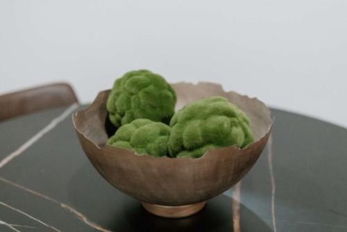a bowl of green balls on a table at 2 Beds, Built-in Office, Gated Entry in Council Bluffs