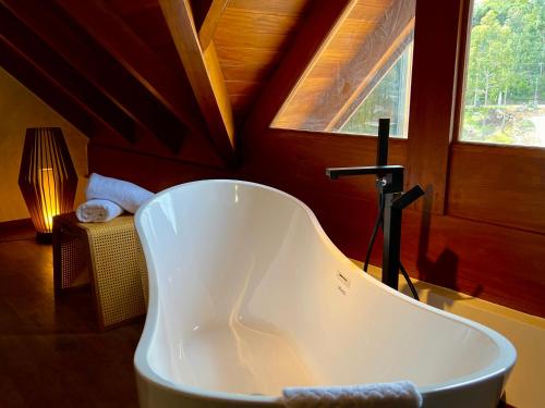 a white tub in a room with a window at WoodStone Hotel Fazenda in Gramado