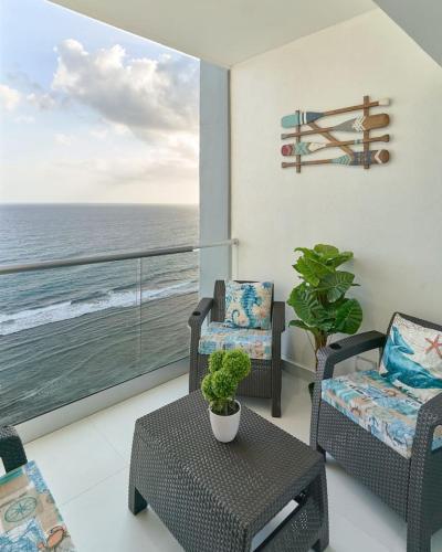 a living room with chairs and a balcony with the ocean at Aquarella Caribbean Blue Summer Special GateAway in La Puntica de Juan Dolio