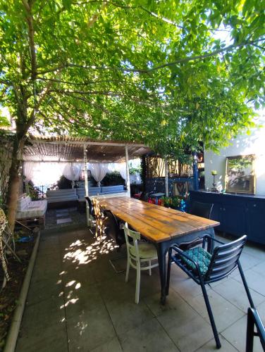 a wooden table and chairs under a tree at Quiet, Comfort and Style close to Basel in Huningue