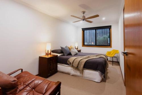 a bedroom with a bed and a ceiling fan at Mid Century on Eastview in Torquay