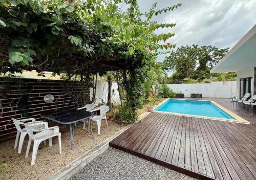 a backyard with a pool and a table and chairs at Sunshine Serenity Villa in Grand Baie