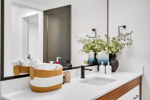 un baño con lavabo y espejo en Cozy 1BR Pullout Couch Discovery Ridge, en Calgary