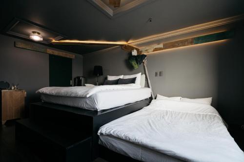two beds sitting next to each other in a room at All New Diamond House in Busan