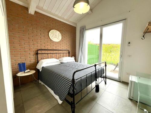 a bedroom with a bed and a brick wall at Casa Gardenia -affittacamere in Gatteo