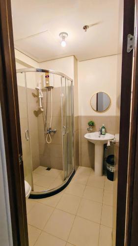 a bathroom with a shower and a sink at Bella Suite Netflix Pool Great View in Manila