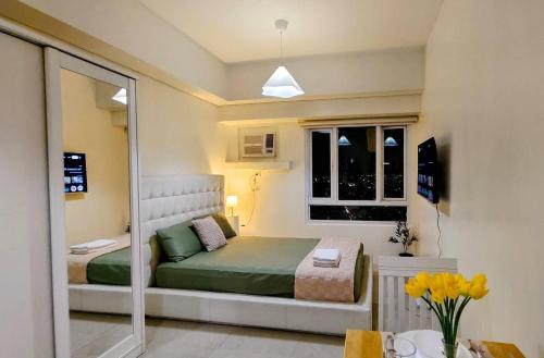 a small bedroom with a bed and a window at Bella Suite Netflix Pool Great View in Manila