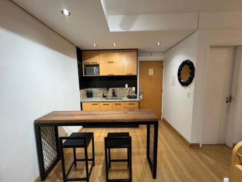 a kitchen with a wooden table and some chairs at Hotel Biena Ibirapuera UH902 in Sao Paulo