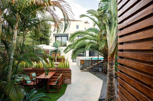 a garden with palm trees and a wooden fence at Casa do Contador - Suites & Pool in Ponta Delgada