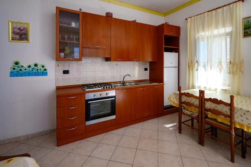 a kitchen with wooden cabinets and a sink and a table at Vista Mediterranea in Pizzo
