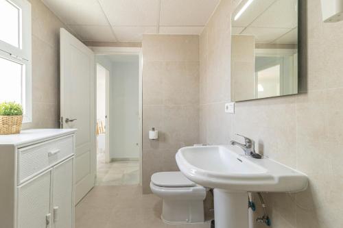 a white bathroom with a sink and a toilet at Allo Apartments Ático Jaramago Parking Centro 1 Hab in Jerez de la Frontera