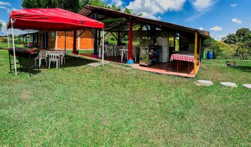 a pavilion with a table and chairs in the grass at Villa Milena in Santa Helena