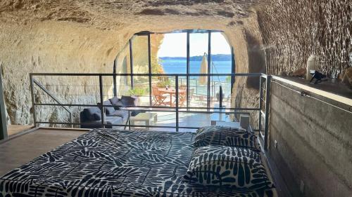 a bed in a room with a view of the ocean at La Baume du Delà in Saint-Chamas