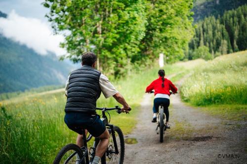 two people riding bikes down a dirt road at Vivea Hotel Umhausen im Ötztal in Umhausen
