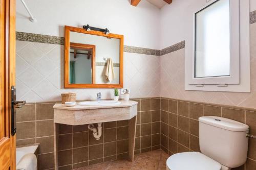 a bathroom with a toilet and a sink and a mirror at Villa Airosa by Villa Plus in Cala'n Porter