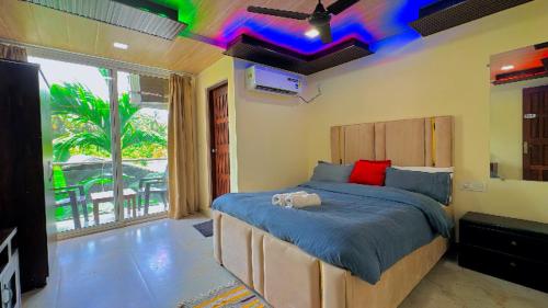 a bedroom with a large bed with a colorful ceiling at Seaside Stay in Arambol