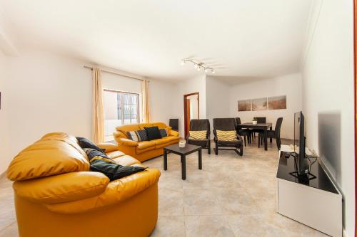 a living room with a couch and a table at Topside Luz Guesthouse in Luz
