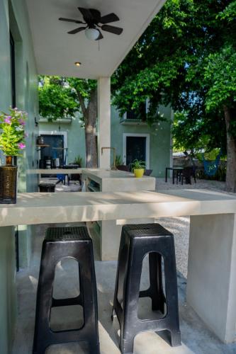 a table with two chairs and a table with a ceiling fan at Charming colonial-style room in the heart of Valladolid in Valladolid