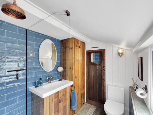 a bathroom with a sink and a toilet and a mirror at Tannery Cottage Porlock in Porlock