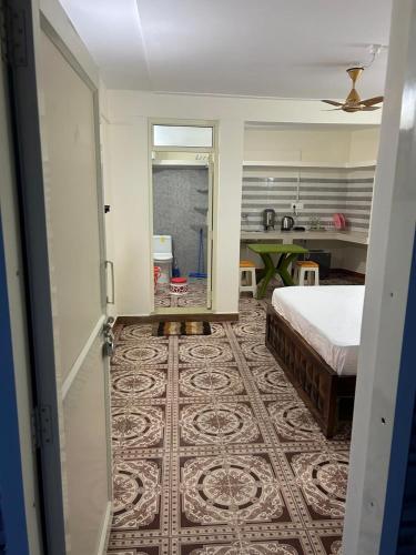 a bedroom with a bed and a room with a kitchen at Fauji Di Hatti in Kandāghāt