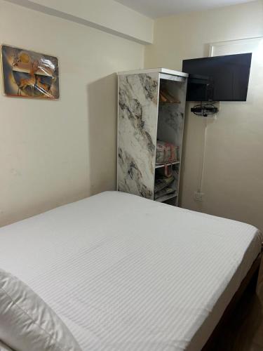 a white bed in a room with a closet at Fauji Di Hatti in Kandāghāt