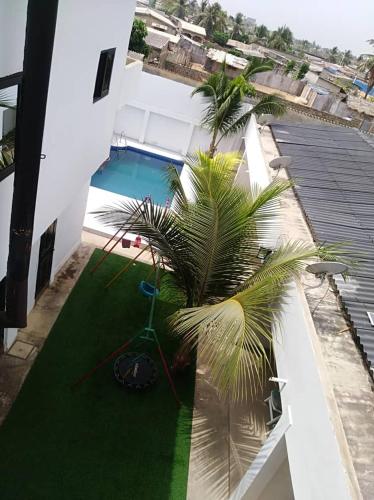 a palm tree on the side of a building with a pool at Bleu Marin Résidence hôtelière in Hila-Kondji