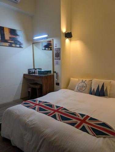 a bedroom with a bed with a british flag blanket on it at 角舍背包客棧 -近火車站 in Hualien City