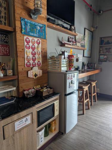 a kitchen with a stove and a refrigerator at 角舍背包客棧 -近火車站 in Hualien City