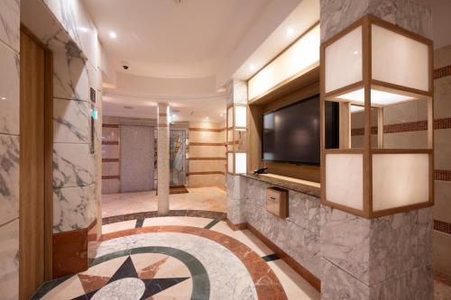 a hotel lobby with a television and a large tile floor at BE FREE HOTELS甲府は2025年8月にカップル専用のホテルをフルリノベーションした まったく新しいスタイルのホテルです様々なご利用者様の自由な過ごし方を提供するホテルとしてBE FREE HOTELsと名付けました in Showa