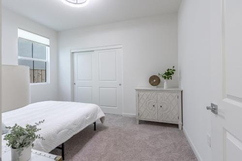 a white bedroom with a bed and a window at Spacious 4BR-3BA Cozy and Modern in Elk Grove in Elk Grove