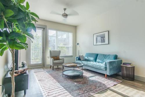 a living room with a blue couch and a table at Boulevard Stays Bright 1BR Suite Pool Parking Gym J in Richardson