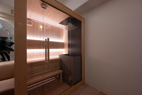 a walk in closet with a glass door at BE FREE HOTELS甲府は2025年8月にカップル専用のホテルをフルリノベーションした まったく新しいスタイルのホテルです様々なご利用者様の自由な過ごし方を提供するホテルとしてBE FREE HOTELsと名付けました in Showa