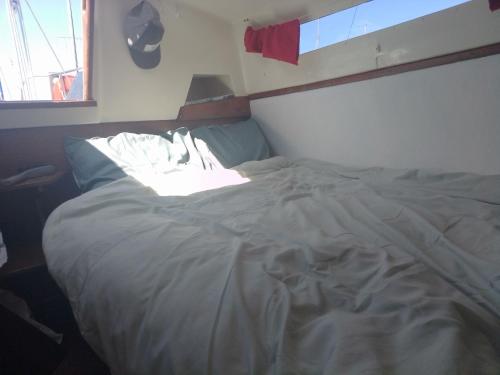 1 cama no hecha en un dormitorio con ventana en Calais Boat, en Calais