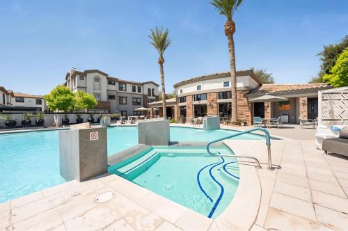 a swimming pool with a slide in a courtyard with palm trees at Boulevard Stays Chic 1BR Near Stadium Pool Access Gym & Free Parking in Glendale