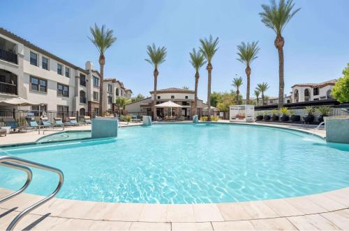 a large pool with palm trees and buildings at Boulevard Stays Chic 1BR Near Stadium Pool Access Gym & Free Parking in Glendale