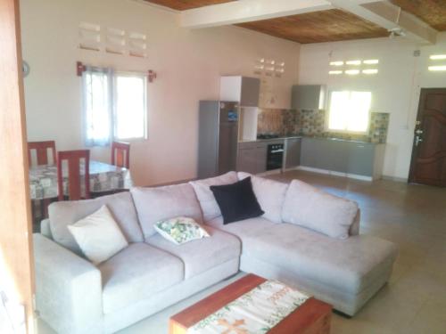 uma sala de estar com um sofá e uma cozinha em Lignitry em Vohemar