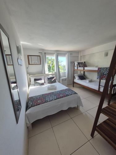 a bedroom with a bed and two bunk beds at Namorada Brava Guest House Praia Brava, Piscina & Naturaleza in Búzios
