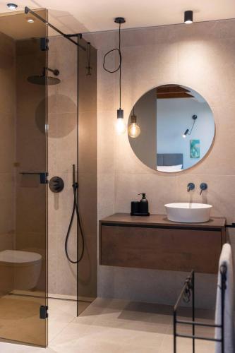 a bathroom with a sink and a shower with a mirror at Mondellebotte - Luxus Villa & traumhafter Meerblick in Barat