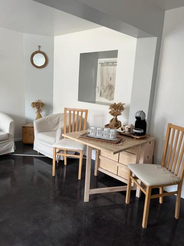 un salon avec une table et deux chaises dans l'établissement Les Jardins d'Eva et Gotham, à Civières