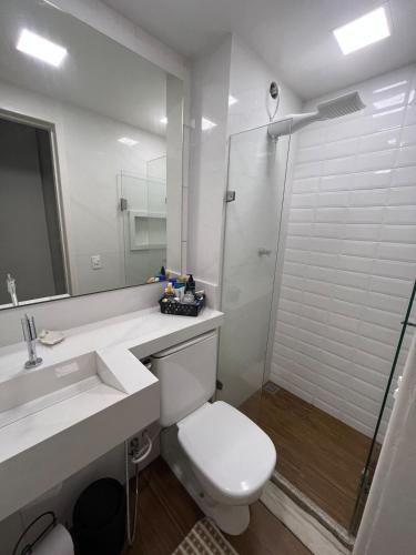 a bathroom with a toilet and a sink and a shower at Apartamento com piscina a poucos passos da praia in Niterói