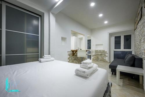 a bedroom with a white bed and a living room at Chiabrera11 Aquarium - Genovainrelax in Genova