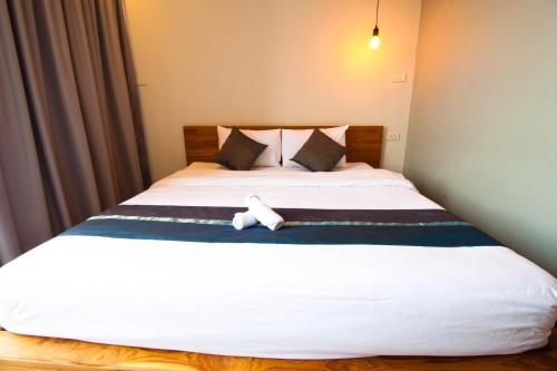a bed with a teddy bear sitting on top of it at 3 Laan House in Chiang Mai
