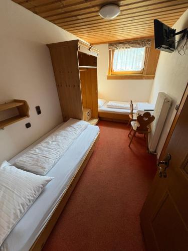 a bedroom with a large bed and a window at Bergsteiger-Zimmer Pension Obermair in Mayrhofen